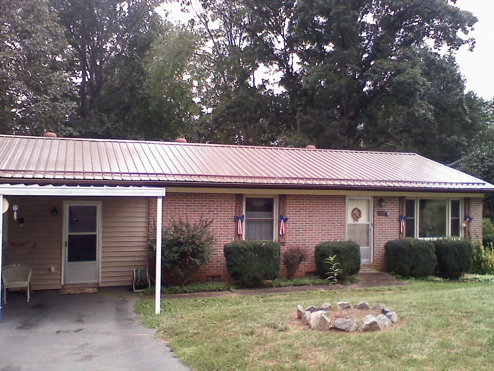 Bronze metal roof and carport on a brick ranch home — Roof Repair work by our crew in Augusta Springs