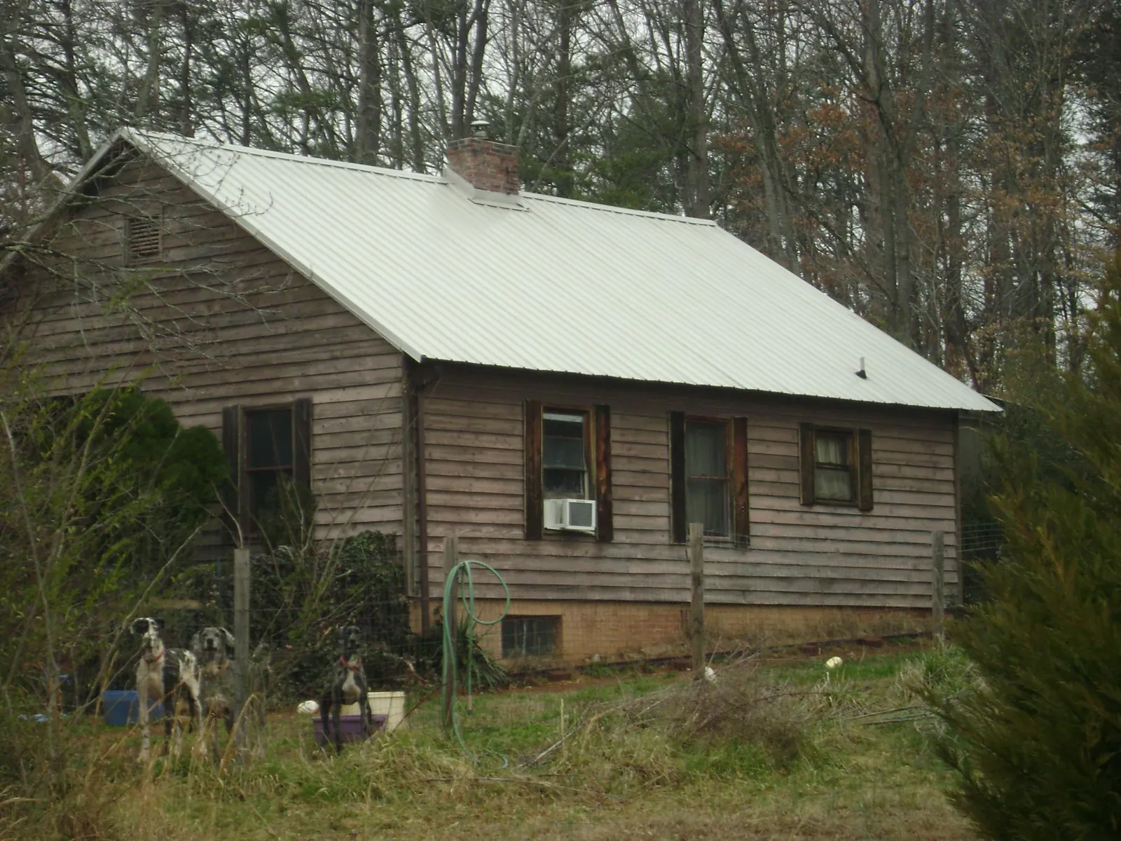 White metal roof on an old wood sided farmhouse, from a Metal Roof Installation job in Augusta Springs